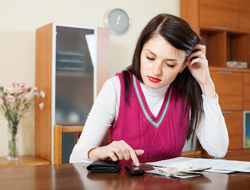 serious housewife filling in utility payments bills