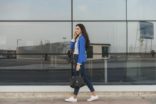 happy-young-woman-talking-on-the-phone-and-walking_23-2147605097